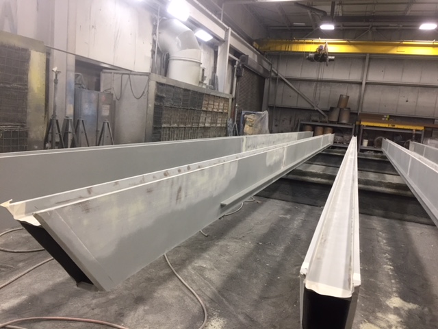 a photo of a steel beam inside the Inter-City Contracting shop during the finishing processing