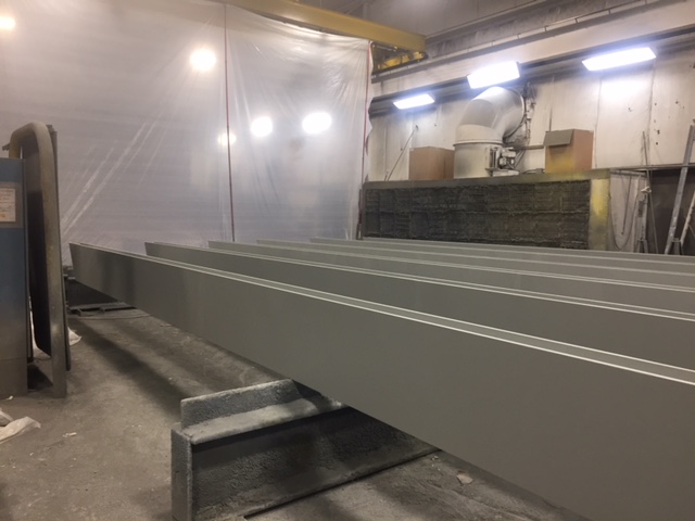 a side view of an AESS steel beam inside the Inter-City Contracting shop after the finishing process