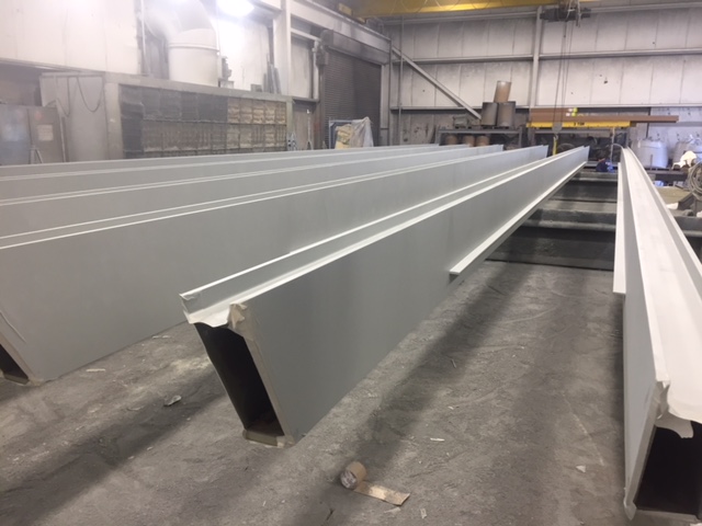 a photo of an AESS steel beam inside the Inter-City Contracting shop after the finishing processing