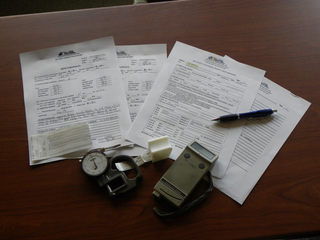 a photo displaying the quality control paperwork, guages, and guage readouts used to ensure that Inter-City Contracting jobs meet the high expectations of their customers