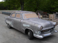 a vintage car has been stripped down to bare silver metal using plastic media blasting