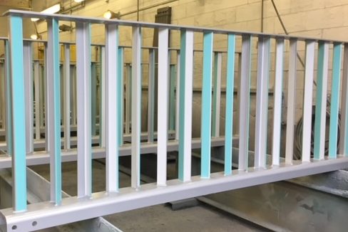 a photo of completed decorative railings with a silver, blue, and white duplex coating system applied