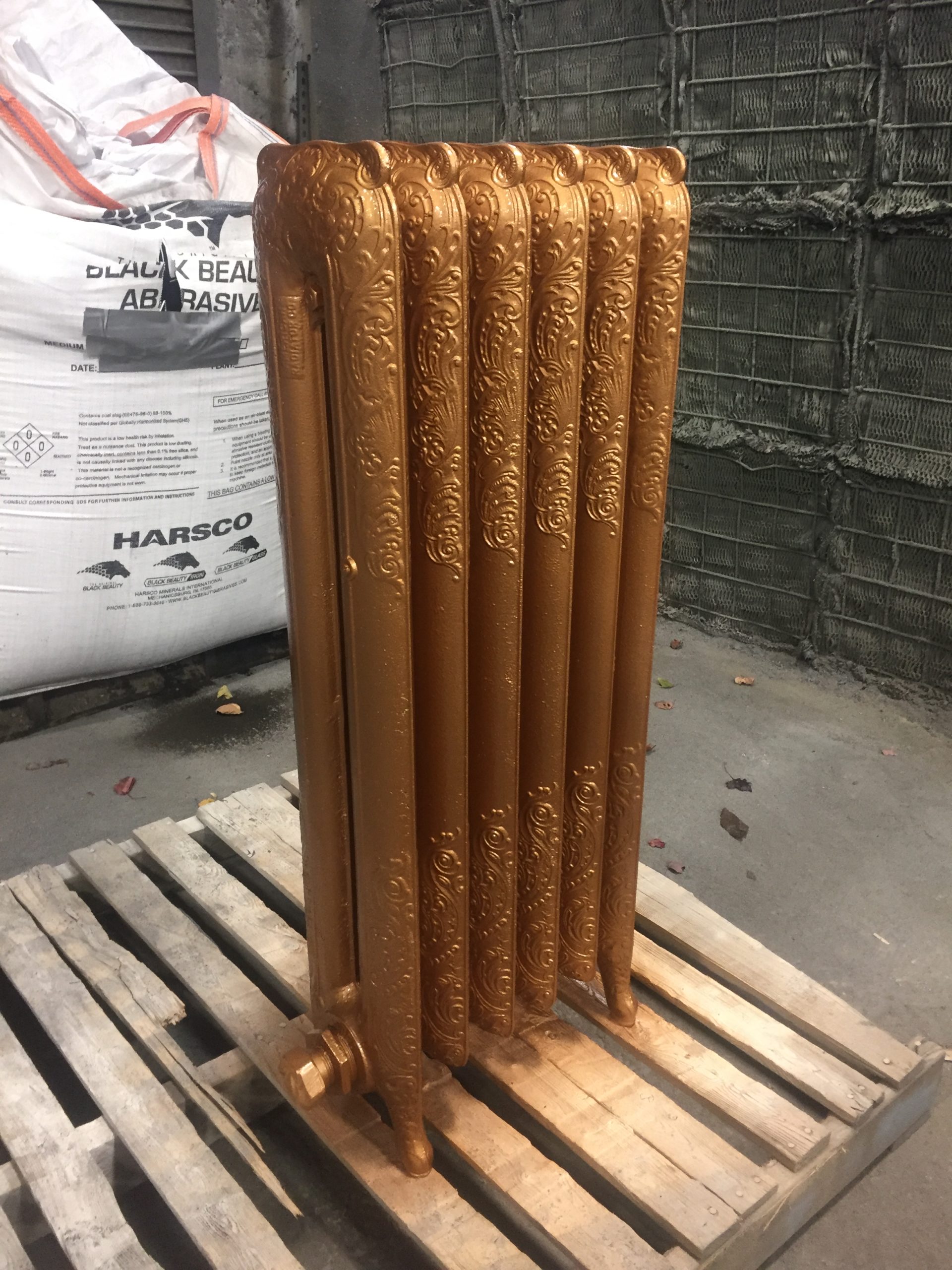 a decorative steam radiator restored and recoated with a metallic copper finish