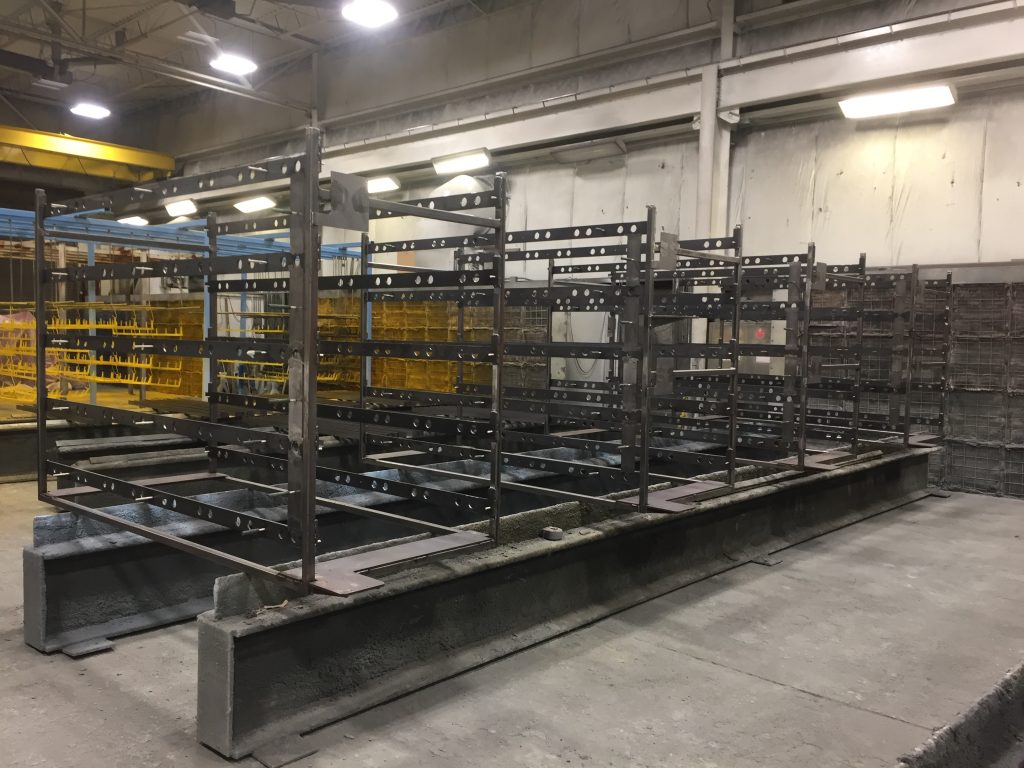 a set of dull gray steel frames are arranged in an Inter-City Contracting workspace prior to being painted